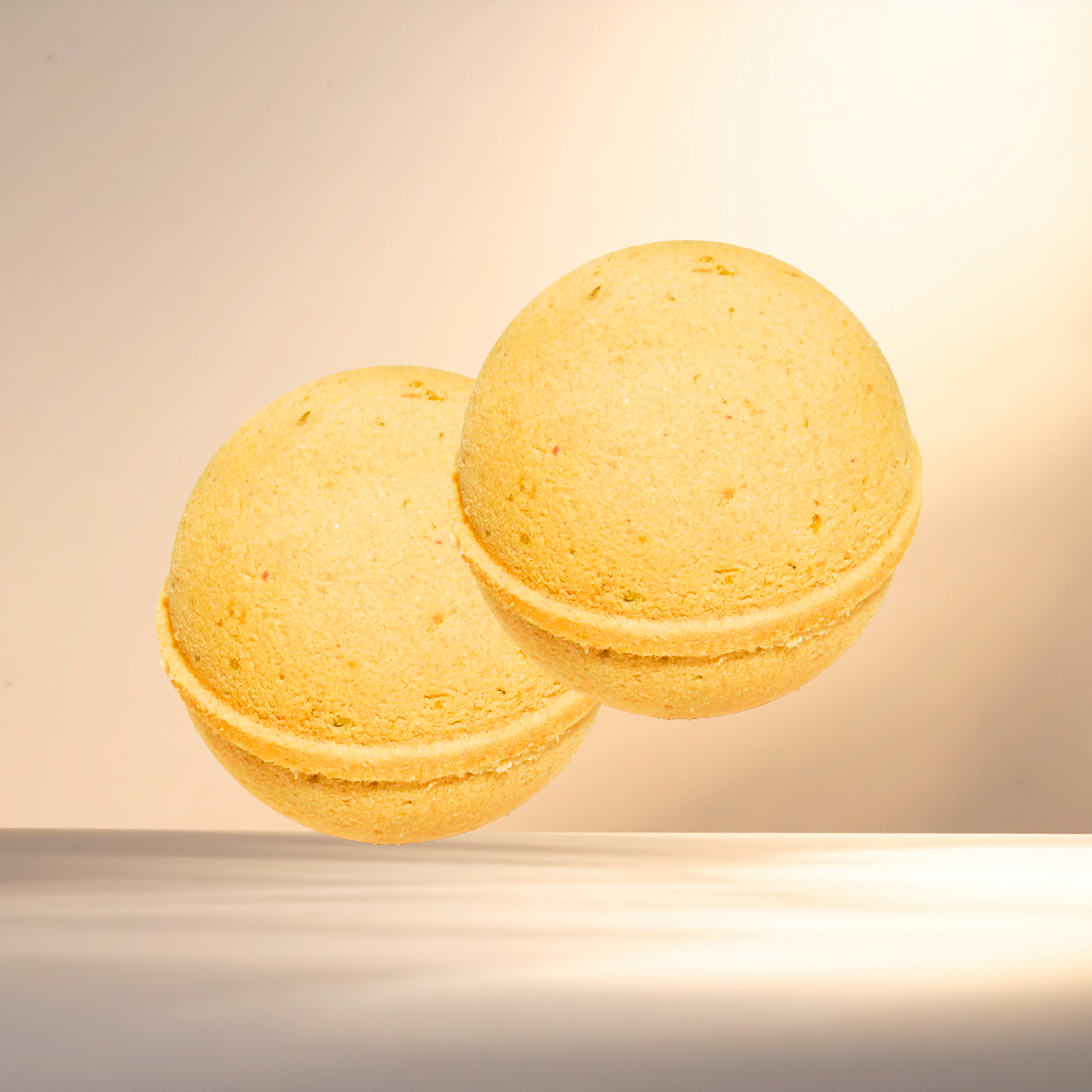 Two yellow bath bombs on a beige background