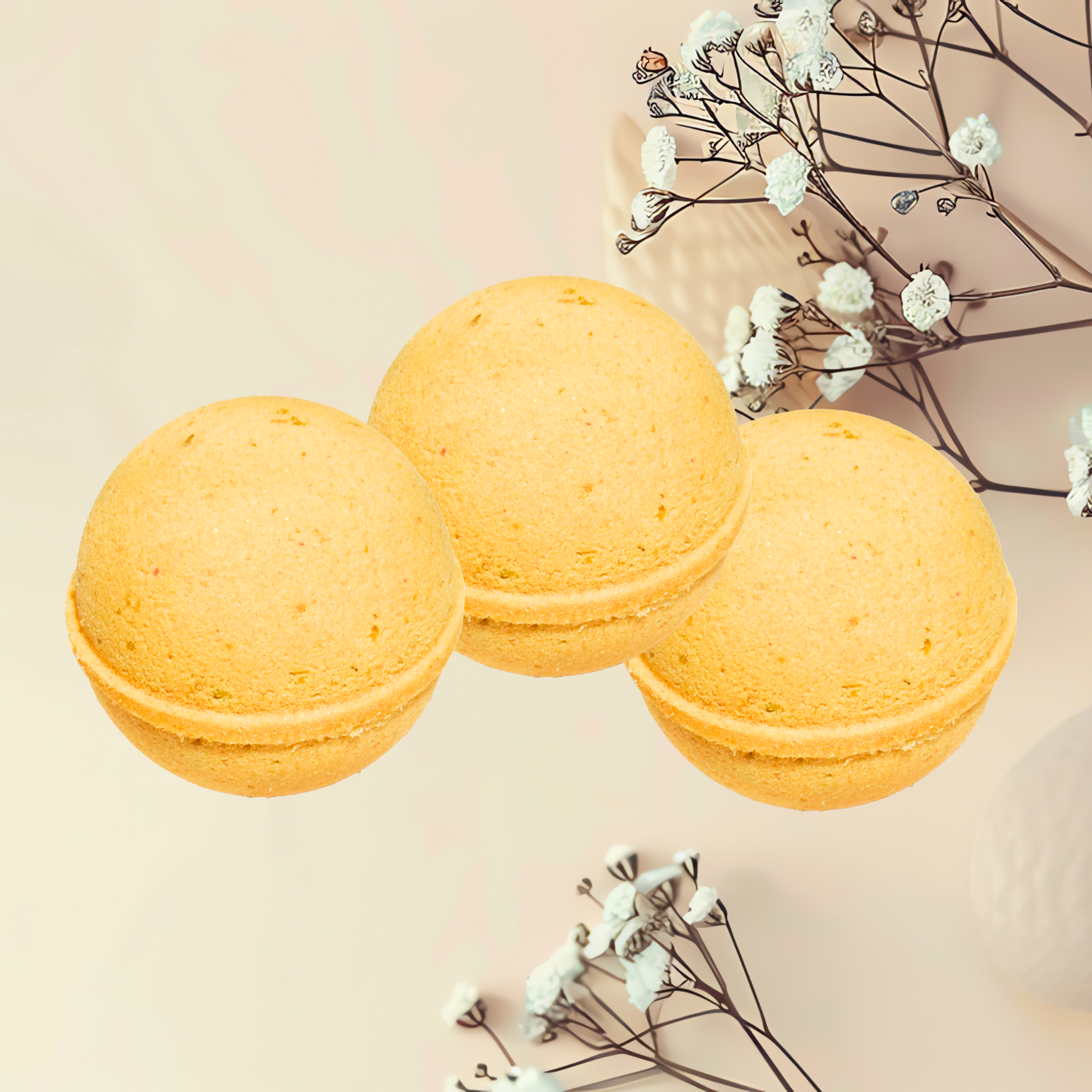 Three yellow bath bombs with white flowers on a beige background