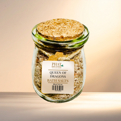 Jar of 'Queen of Dragons' bath salts with a cork lid on a gradient background
