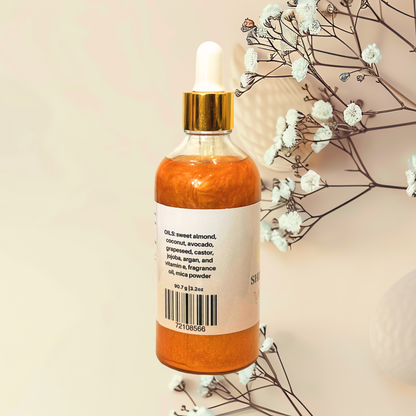 Bottle of gold liquid with a dropper on a beige background with white flowers.