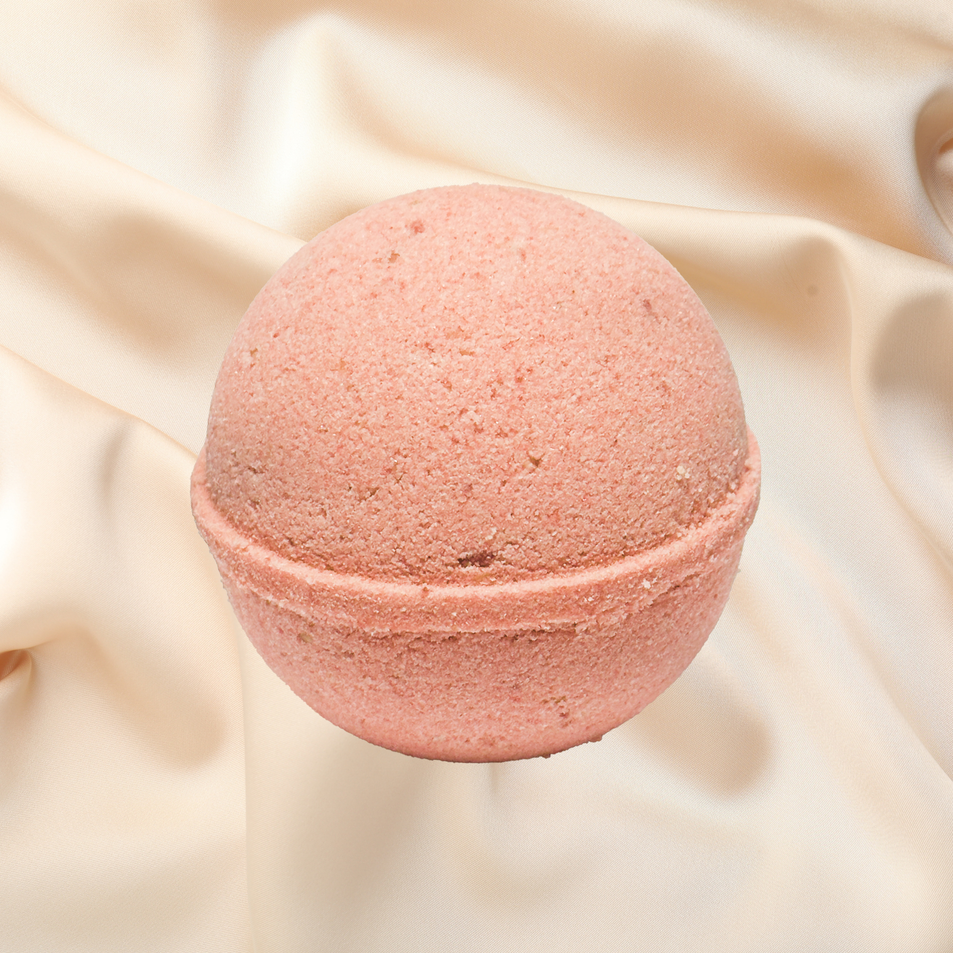 Pink bath bomb on a beige fabric background