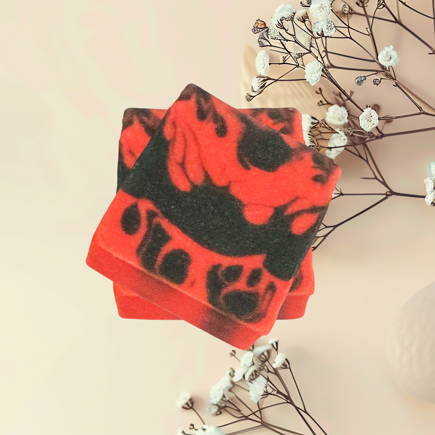 Red and black soap bars with a paw print design on a beige background with white flowers.