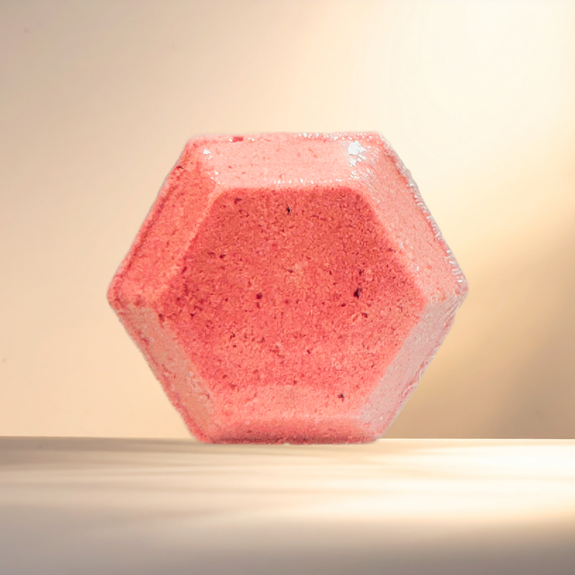 Hexagonal pink shower bomb on a beige background