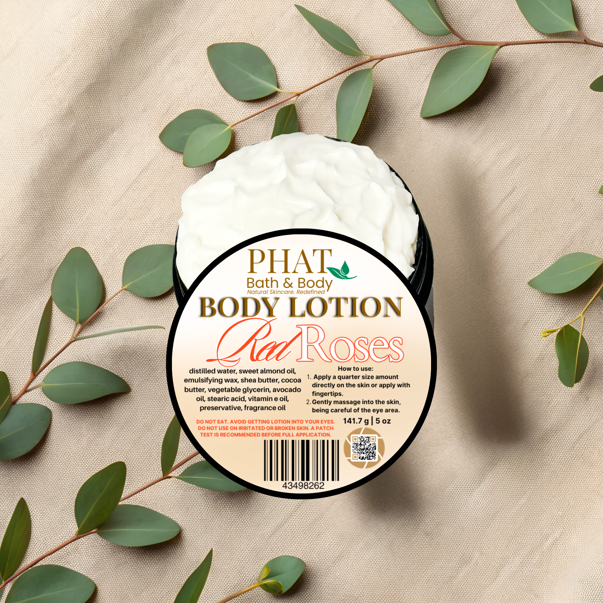 Body lotion container labeled 'Red Roses' from Phat Bath & Body on a beige fabric background with green leaves.