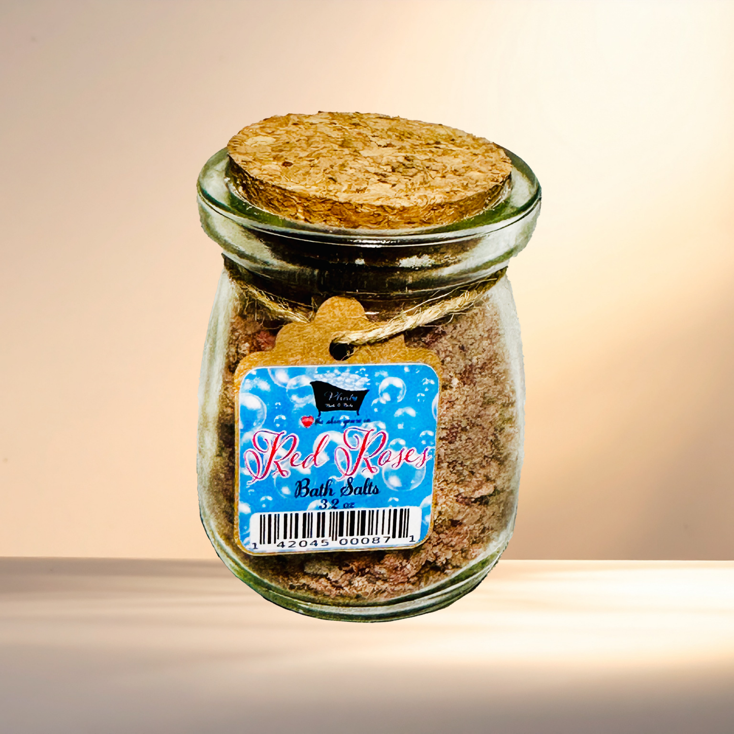 Glass jar with cork lid containing bath salts labeled 'Red Roses' on a gradient background