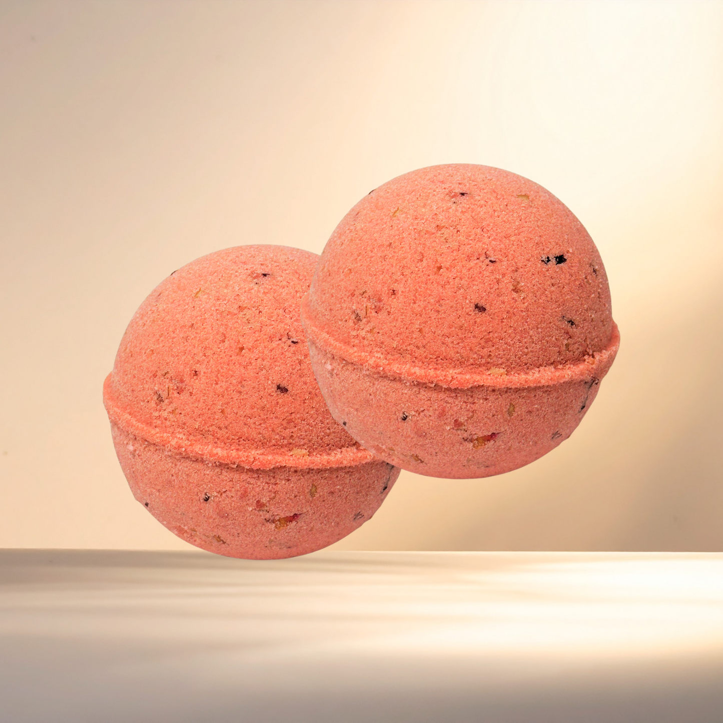 Two red bath bombs on a beige background