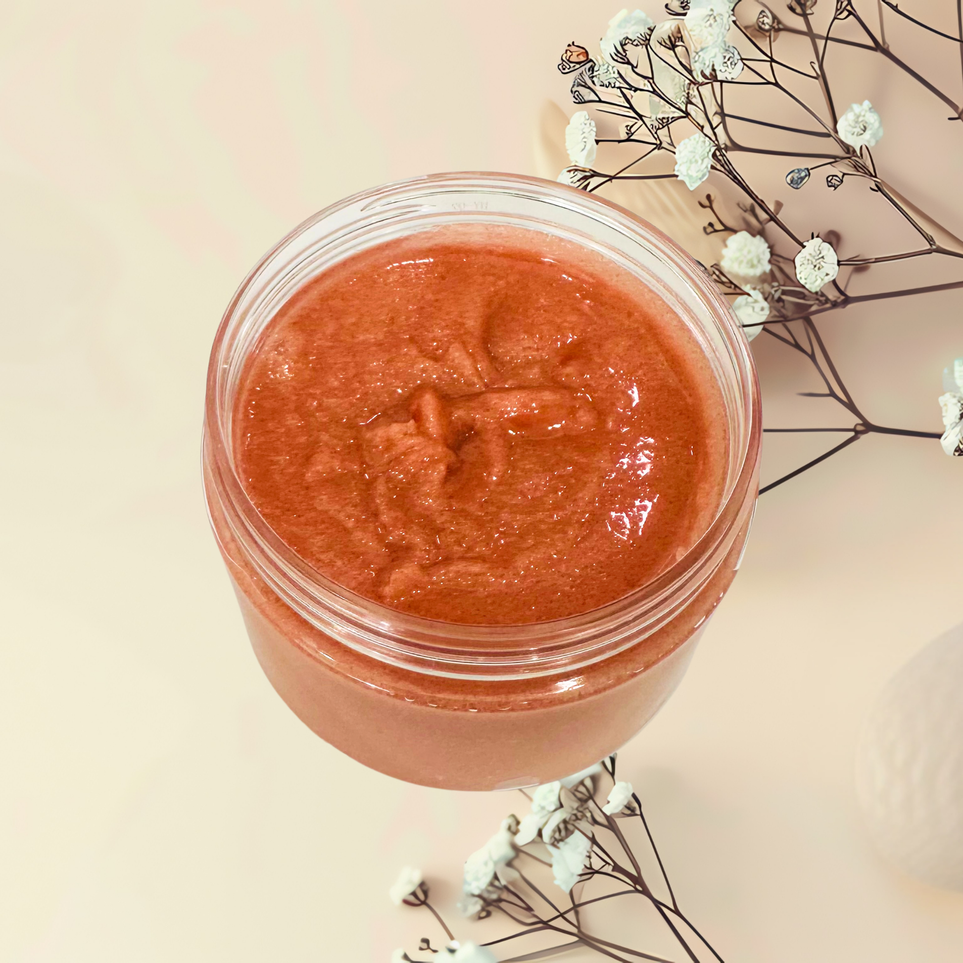 Jar of red scrub with flowers on a beige background