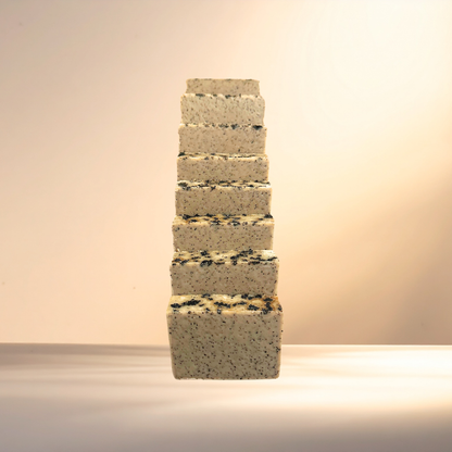 Stack of square soaps with a textured surface on a neutral background