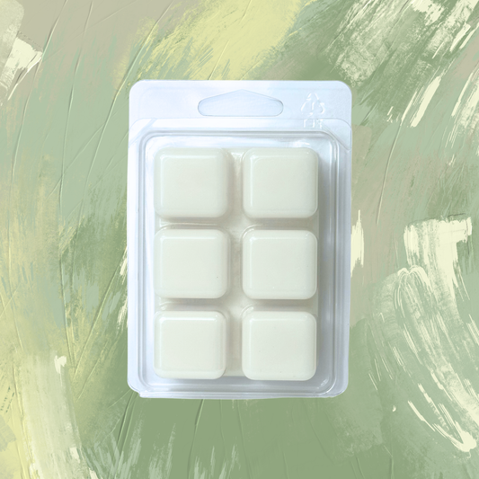Packaged white wax melts on a green textured background