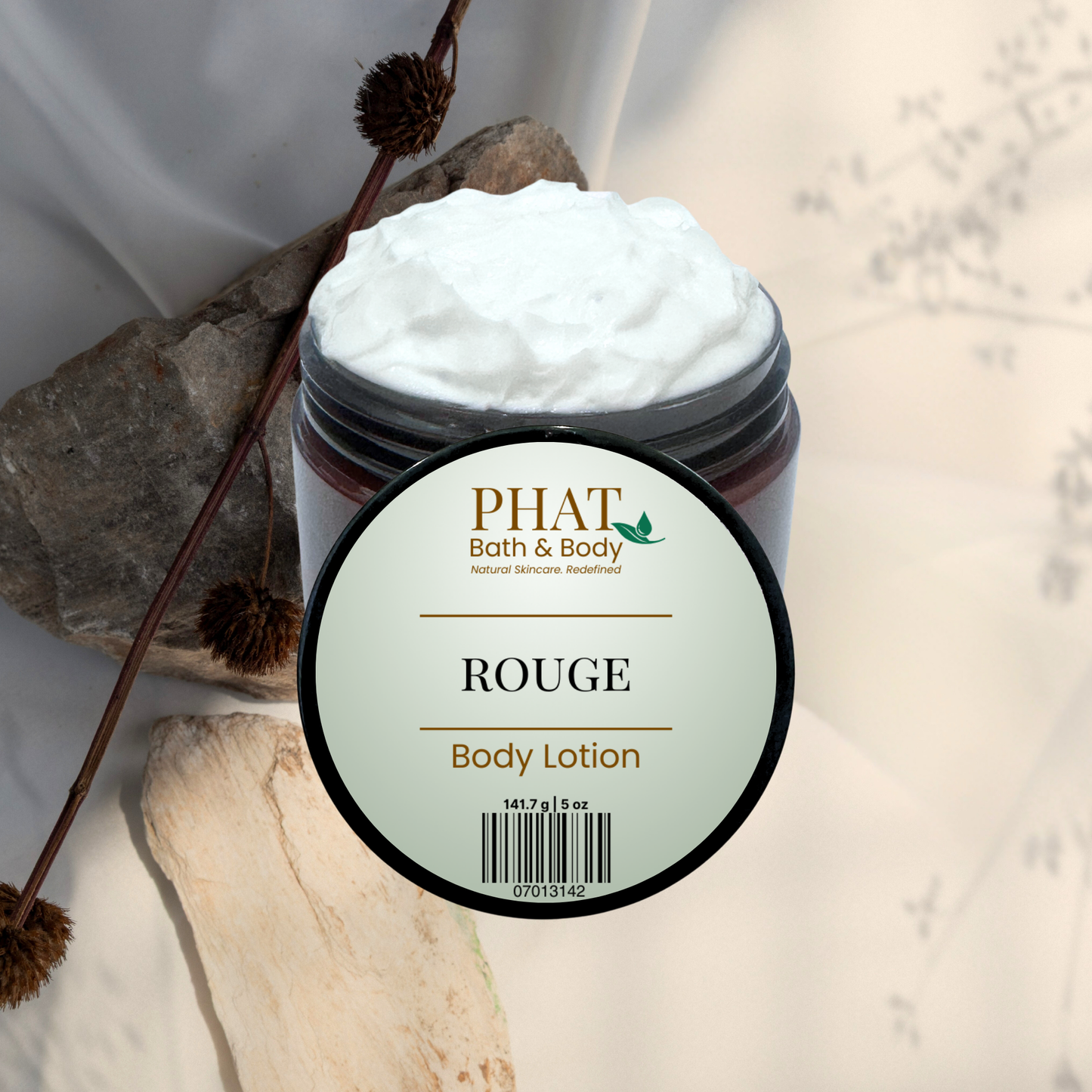 Jar of PHAT Bath & Body Rouge body lotion with natural elements on a light background