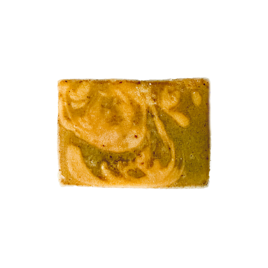 Rectangular bar of soap with green and beige swirls on a white background
