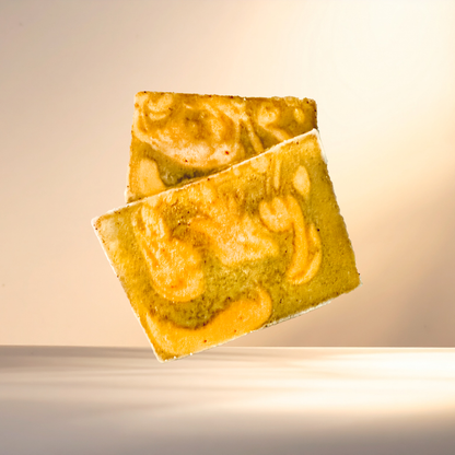 Two marbled soap bars on a reflective surface with a warm glow