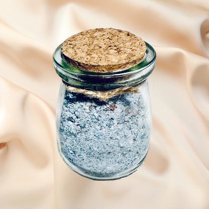Small glass jar with cork lid on a beige fabric background