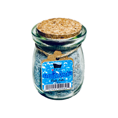 Glass jar with cork lid containing 'Seaside Orchid' bath salts on a white background