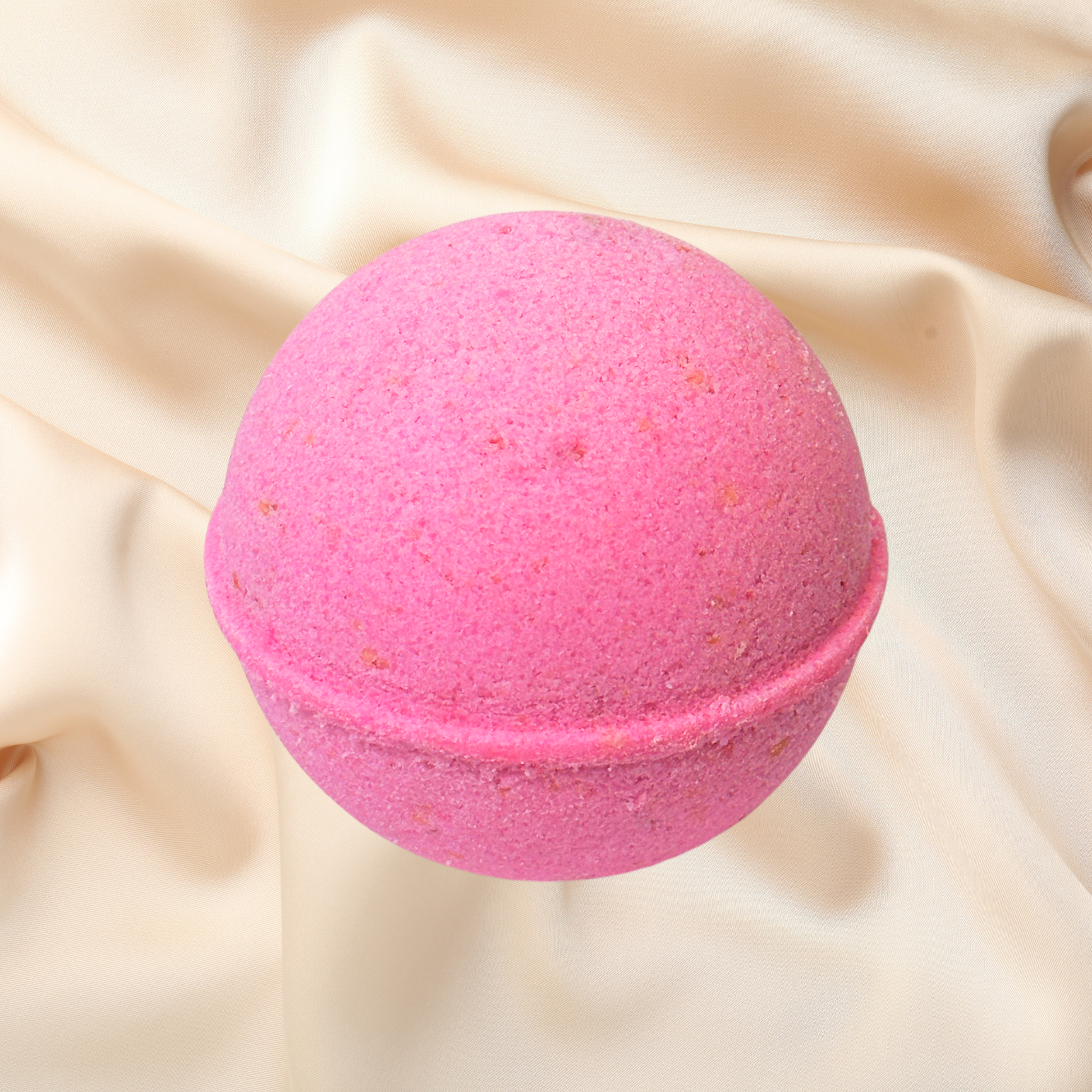 Pink bath bomb on a beige fabric background
