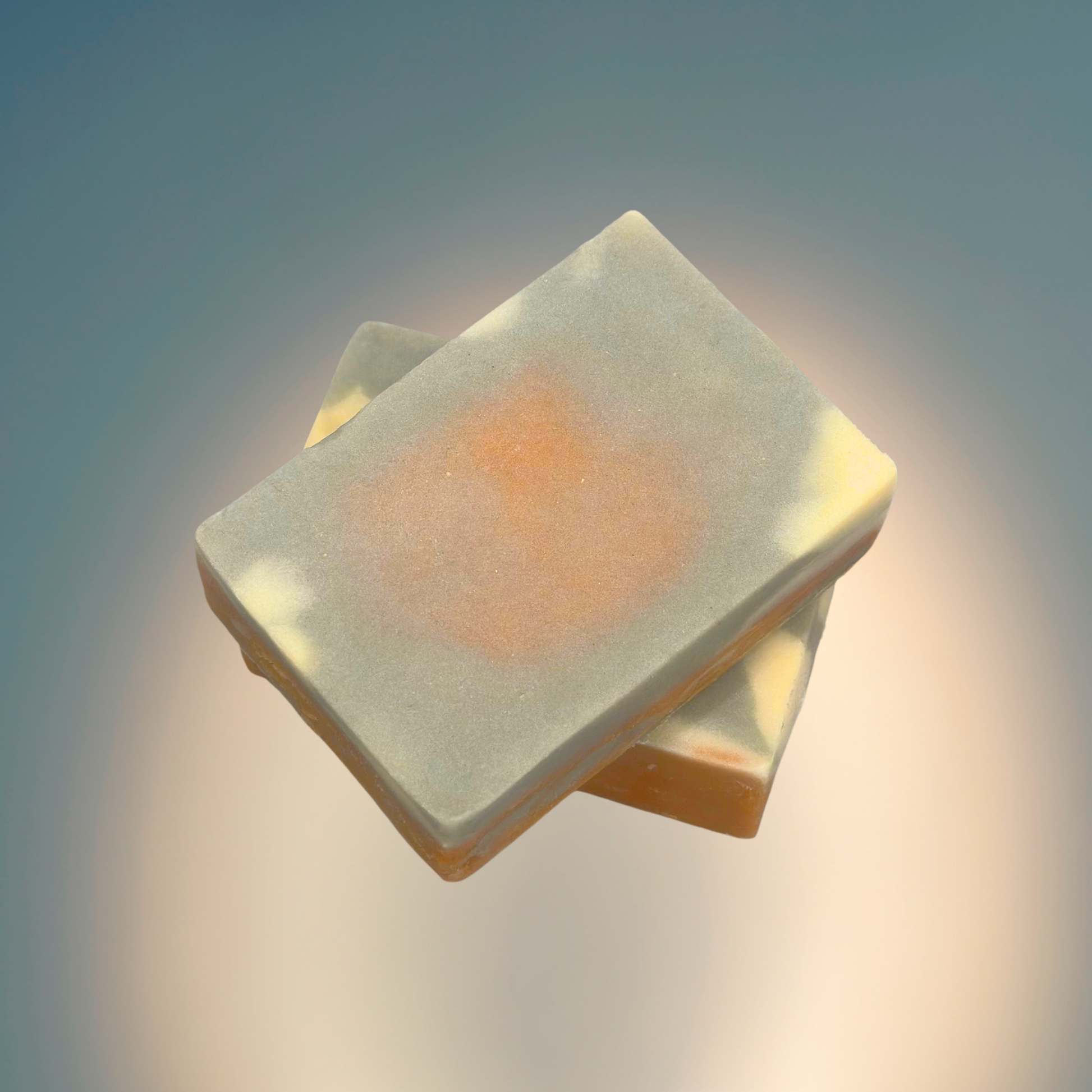 Square bar soap with a central circular depression on a gradient background