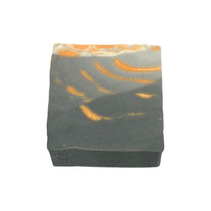 Bar of soap with orange and gray marbled pattern on a white background