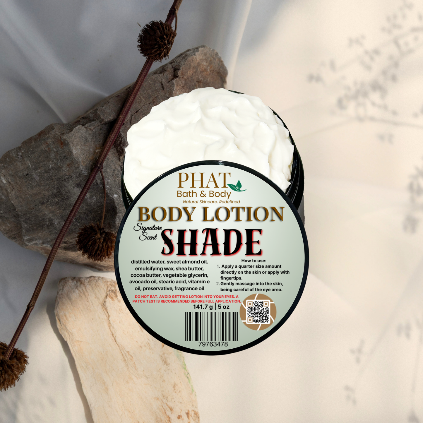 Body lotion container labeled 'Shade' by Phat Bath & Body on a natural stone background.