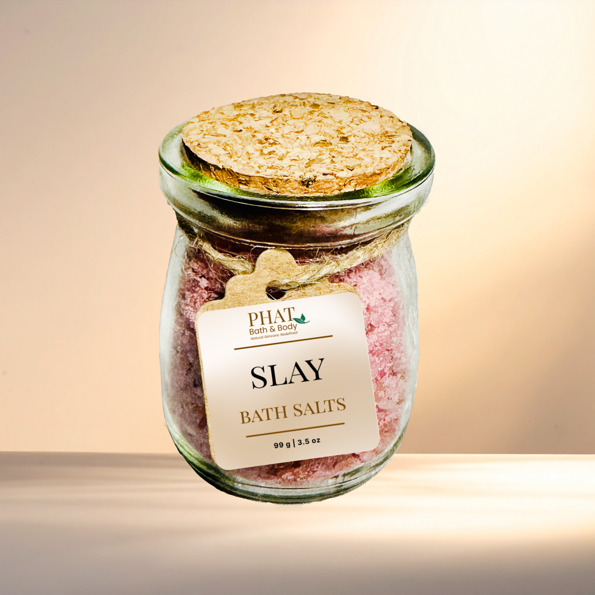 Jar of 'SLAY' bath salts with a cork lid on a gradient background