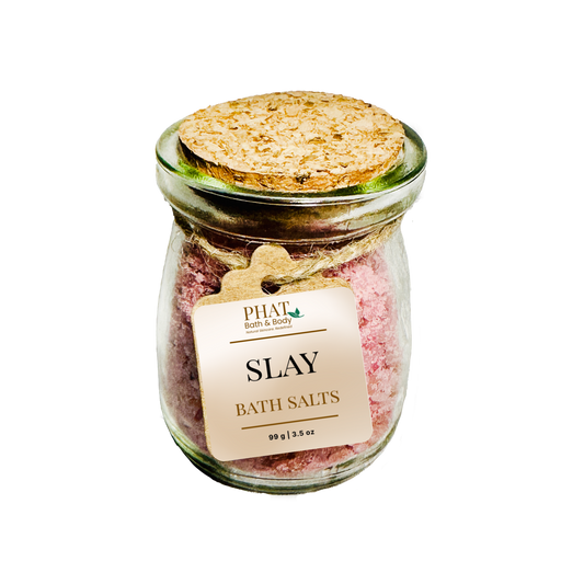 Jar of 'SLAY' bath salts with a cork lid on a white background