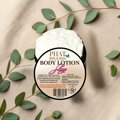 Body lotion container with 'PHAT Bath & Body' branding on a beige fabric background with green leaves.