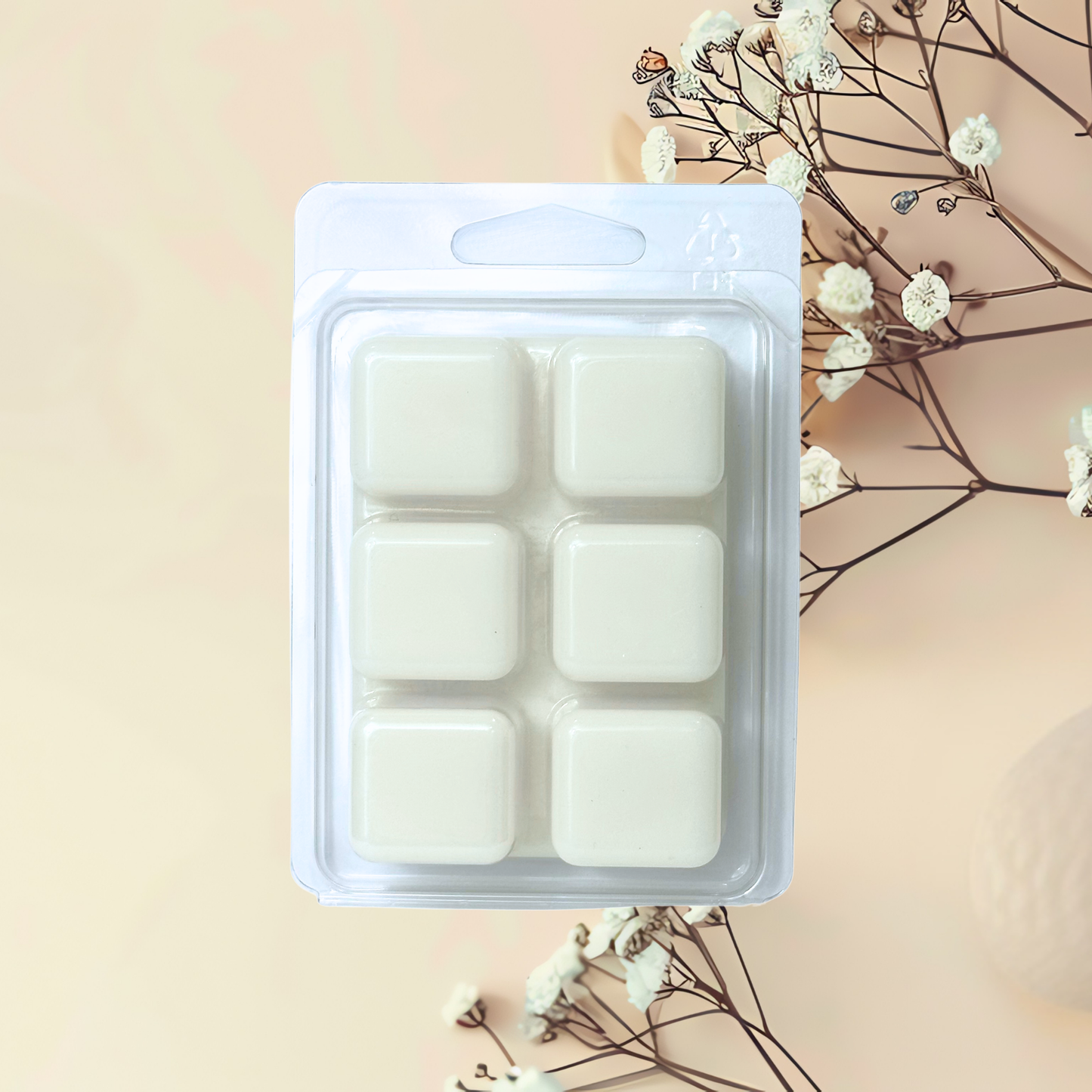 Pack of white wax melts in a clear plastic container on a beige background with decorative elements.