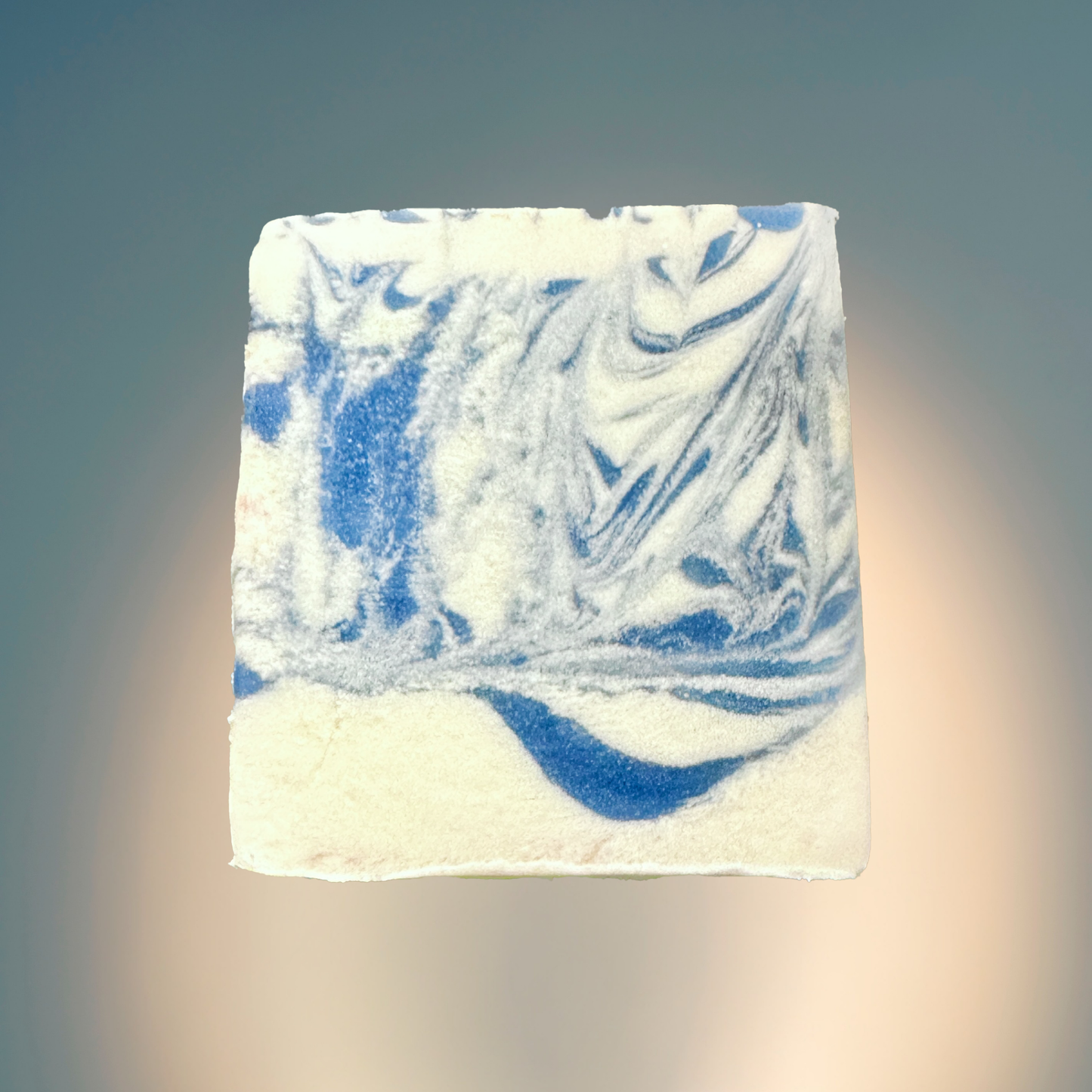 Marbled blue and white soap bar on a gradient background