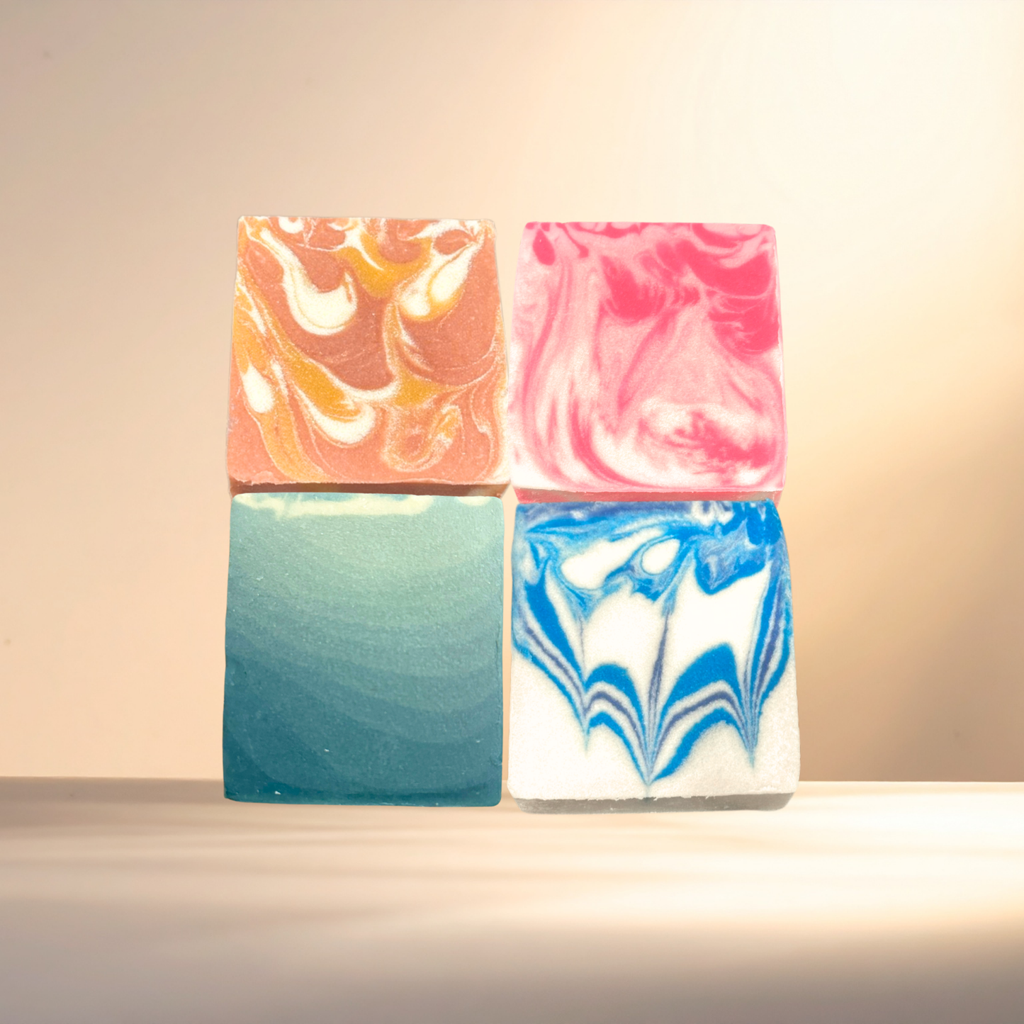 Four colorful marbled soap bars on a light background