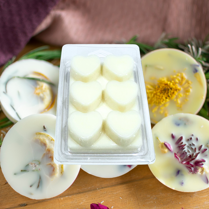 Container of white wax melts with decorative elements on a wooden surface