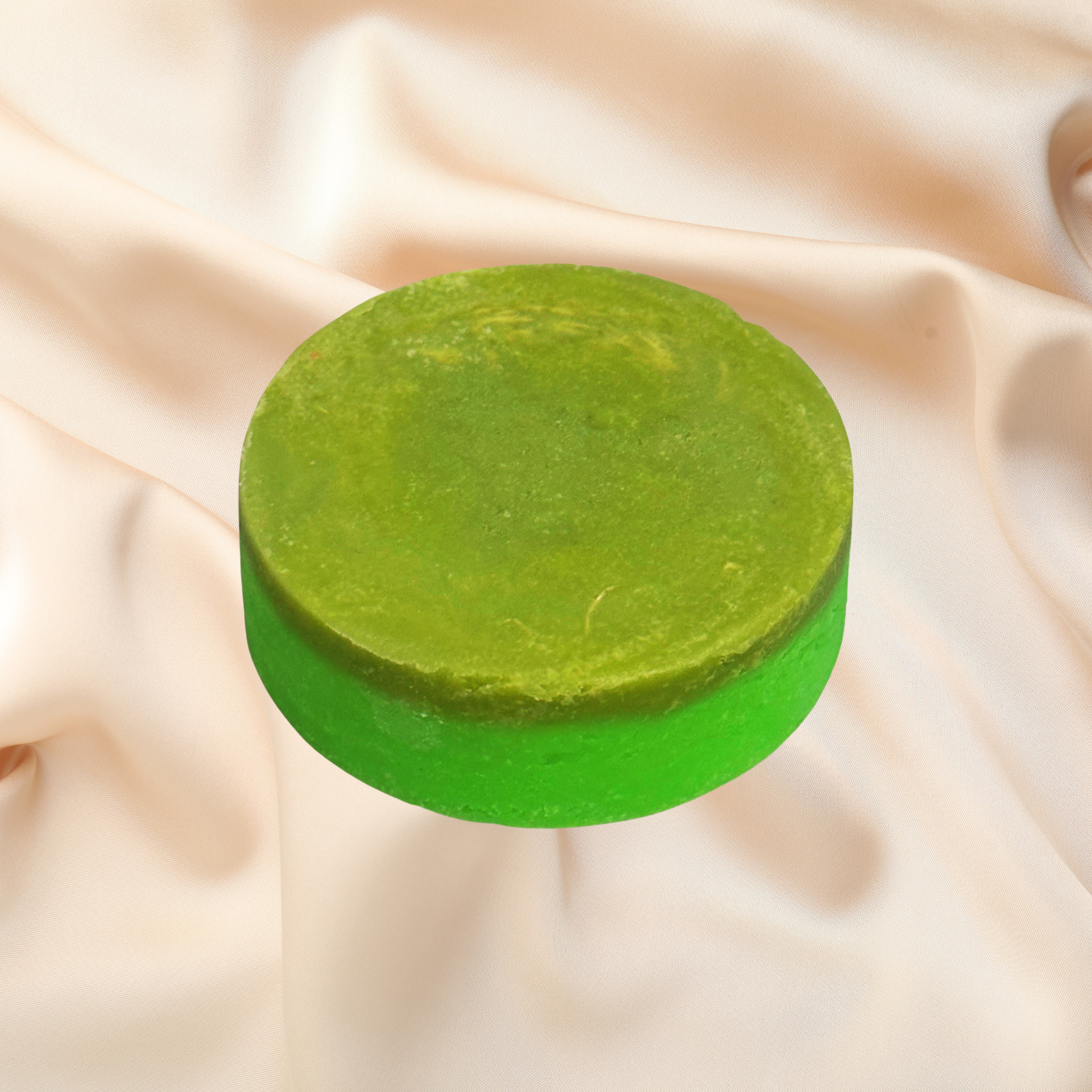 Green bar of soap on a beige fabric background