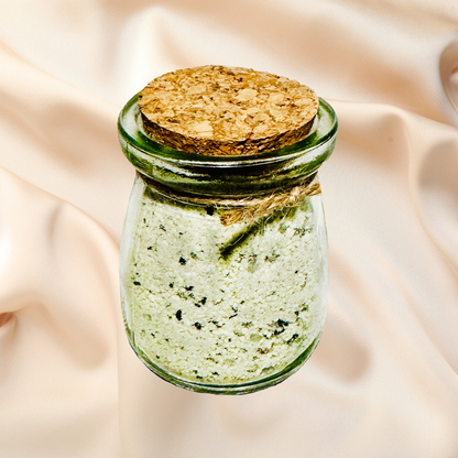 Glass jar with bath salts and cork lid on a beige fabric background