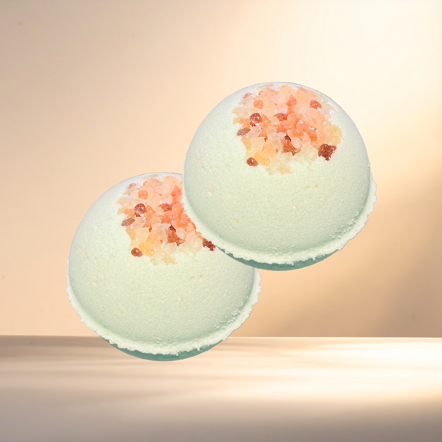 Two bath bombs with decorative elements on a gradient background