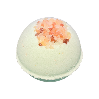 Green bath bomb with pink salt on a white background