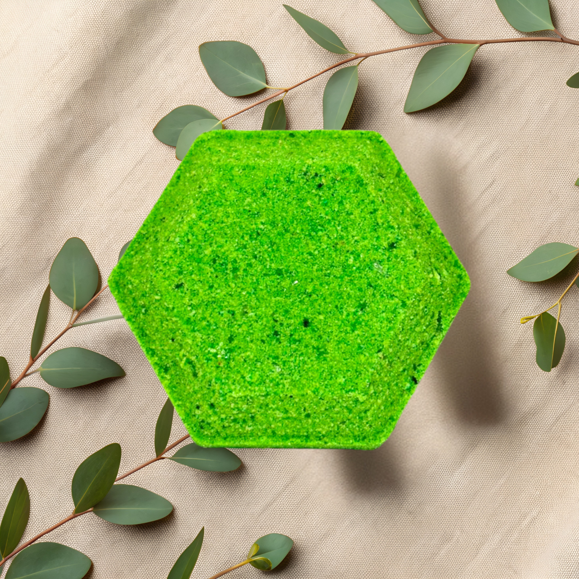 Hexagonal green steamer on a beige fabric background with green leaves