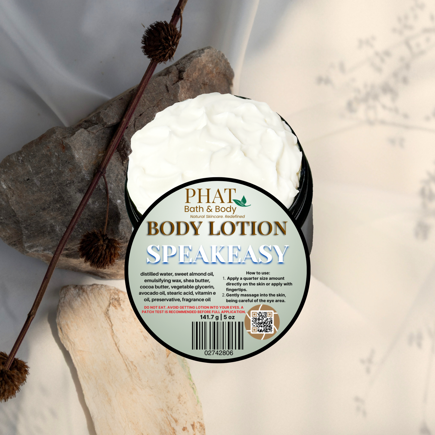 Body lotion container labeled 'Speakeasy' by Phat Bath & Body on a natural stone background.