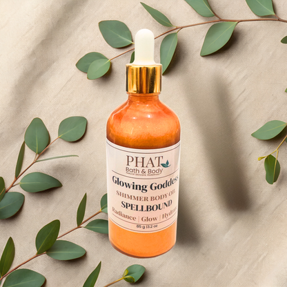 Bottle of PHAT Bath & Body shimmer oil with green leaves on a textured beige background