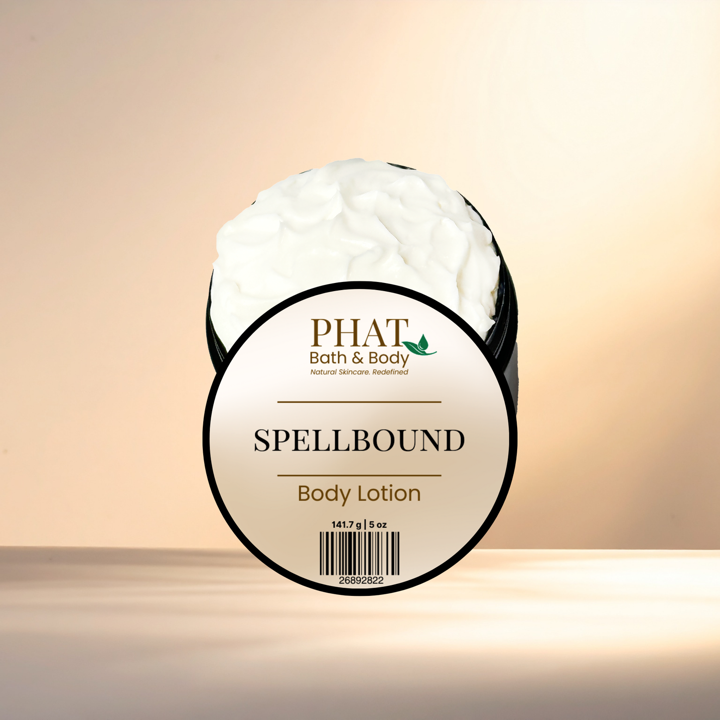 Body lotion jar labeled 'Spellbound' by PHAT Bath & Body on a beige background