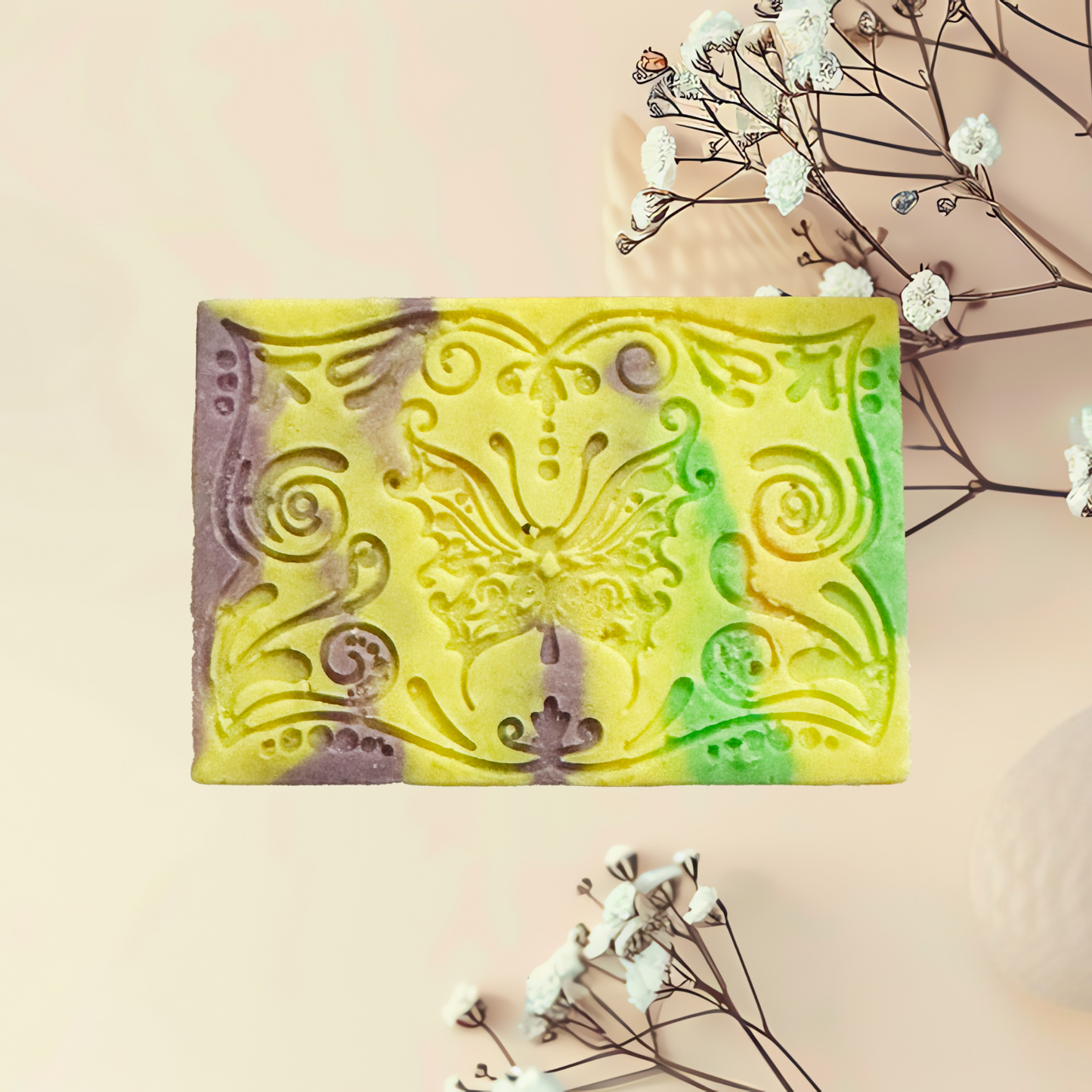 Decorative soap bar with intricate design on a light background with flowers.