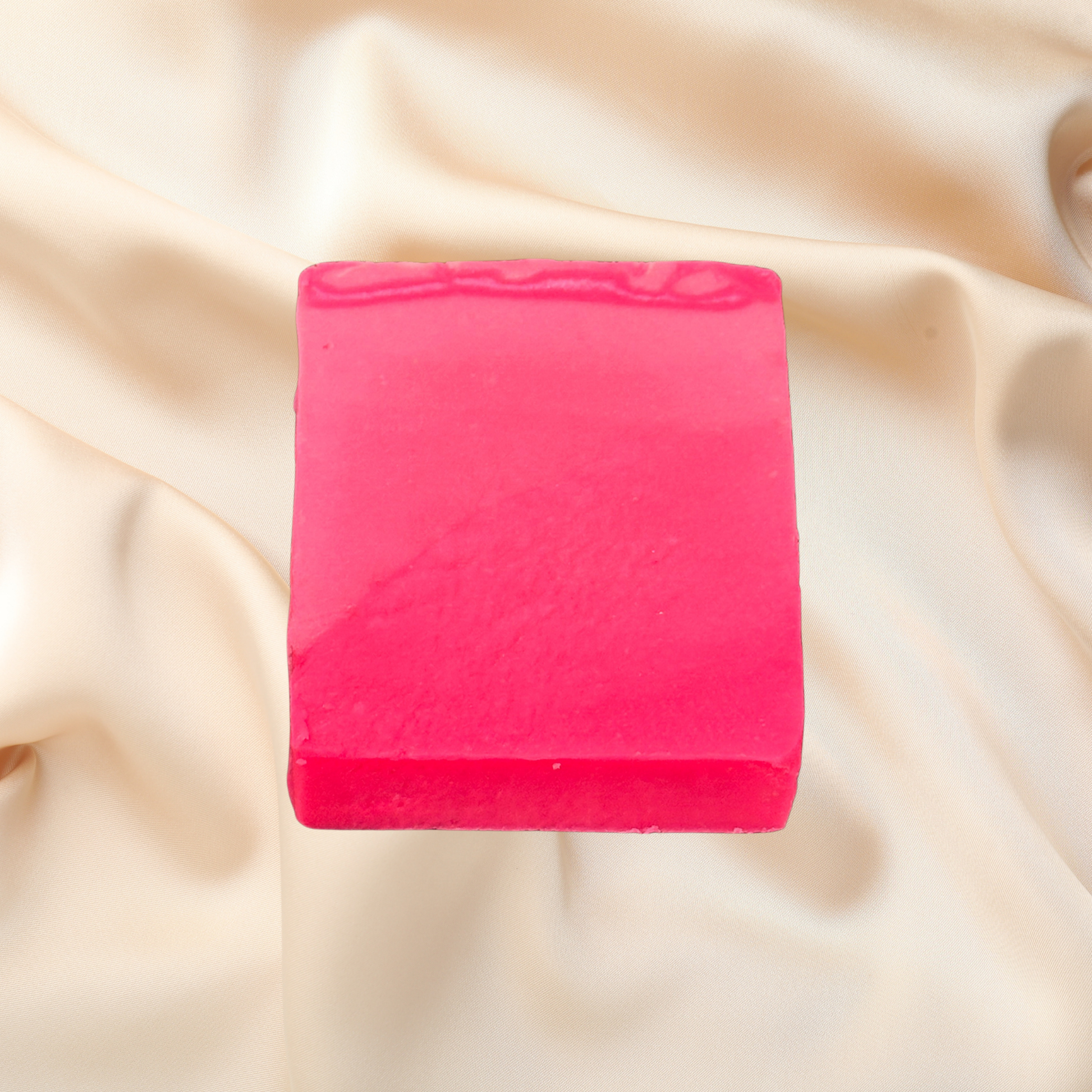 Pink bar of soap on a beige fabric background