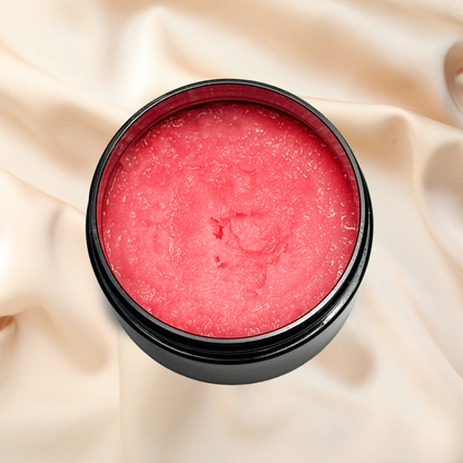 Pink sugar scrub in a black container on beige fabric