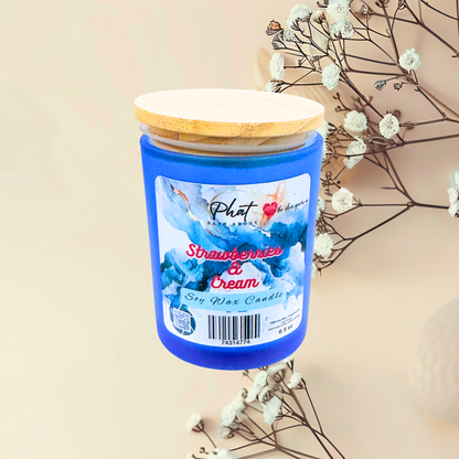 Candle with a blue jar and wooden lid on a beige background with white flowers.