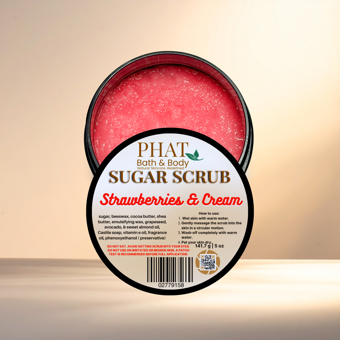 Jar of sugar scrub labeled 'Strawberries & Cream' from Phat Bath & Body on a beige background