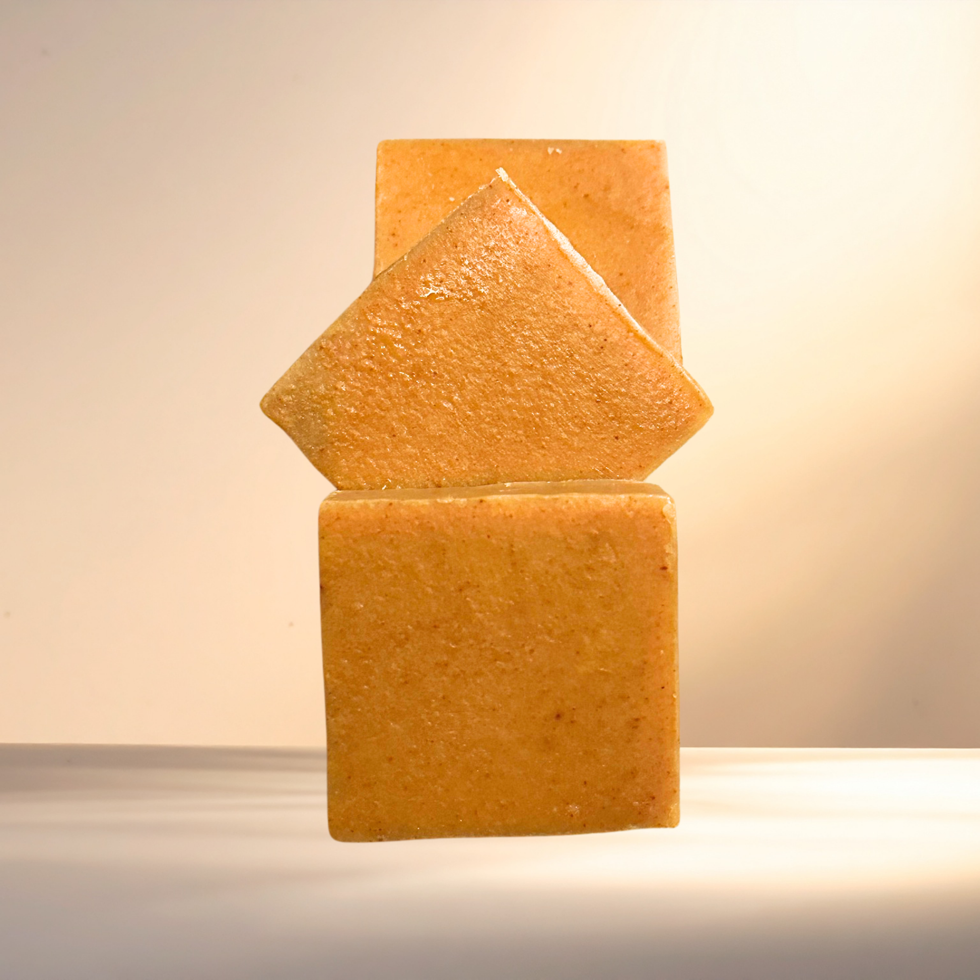Three stacked soap bars on a neutral background