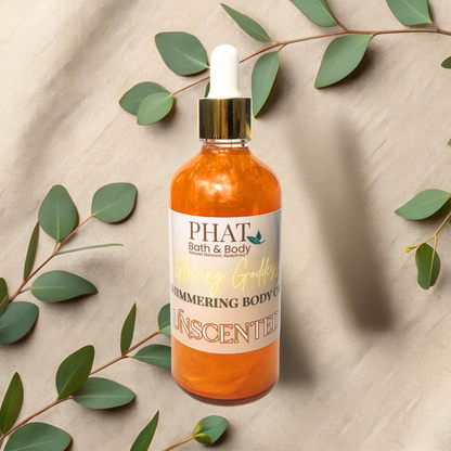 Bottle of PHAT Bath & Body unscented shimmering body oil with green leaves on a beige fabric background