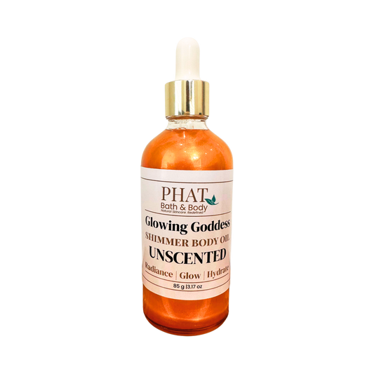 A bottle of PHAT Bath & Body 'Glowing Goddess' shimmer body oil, unscented, in an glass bottle with a white label and a gold-and-white dropper cap, isolated on a white background.