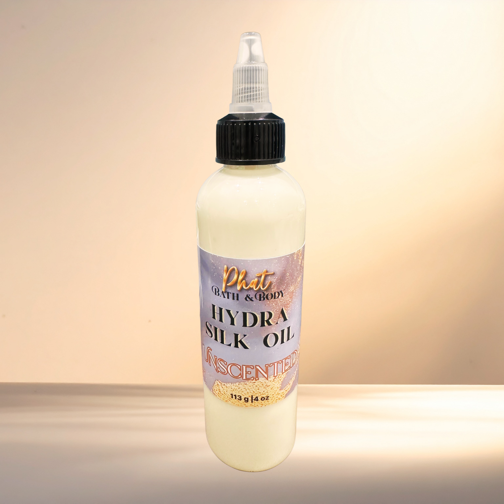 Bottle of Phat Bath & Body Hydra Silk Oil on a gradient background