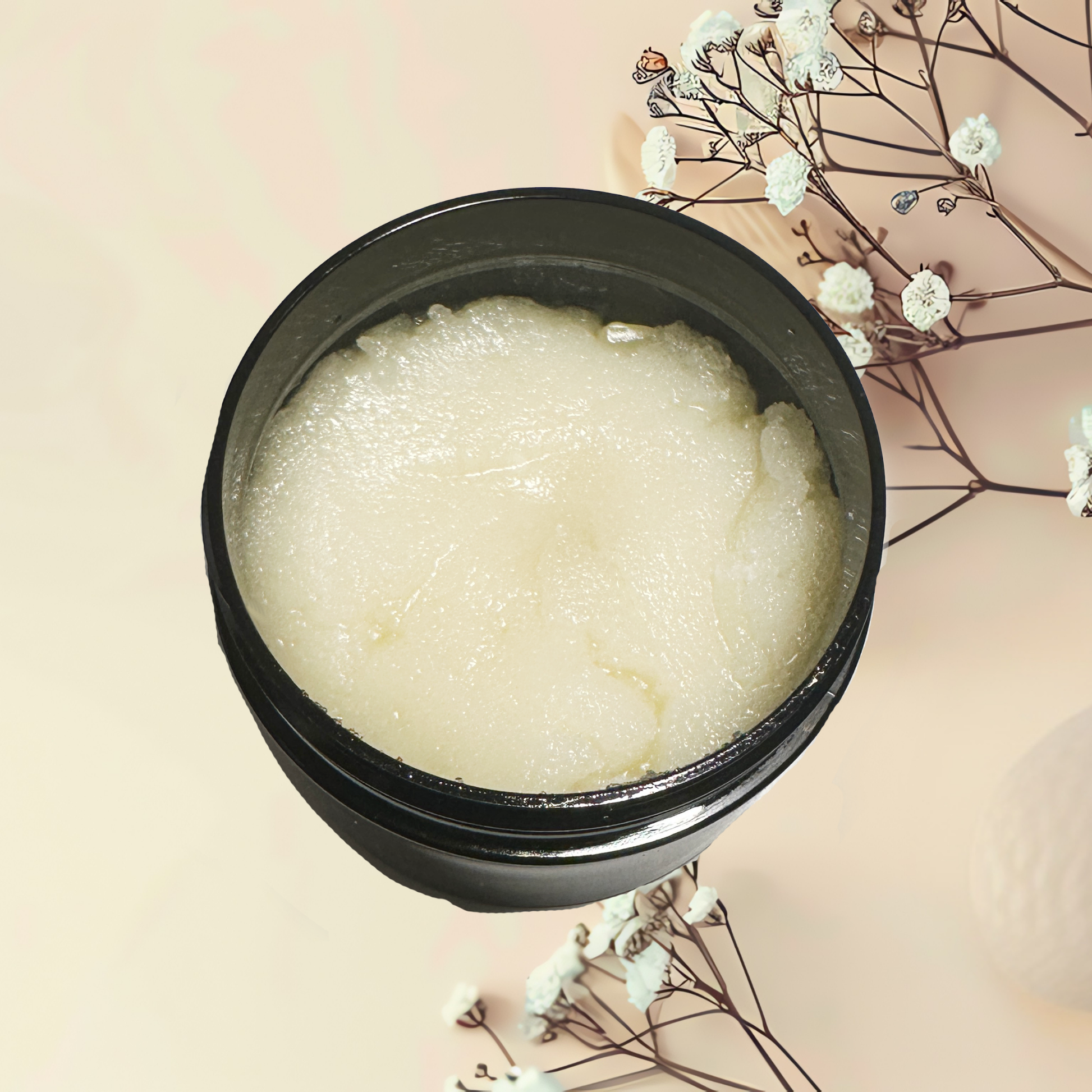Black container with white scrub on a beige background with white flowers.