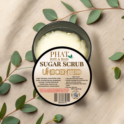 Jar of Phat Bath & Body sugar scrub with eucalyptus leaves on a beige fabric background
