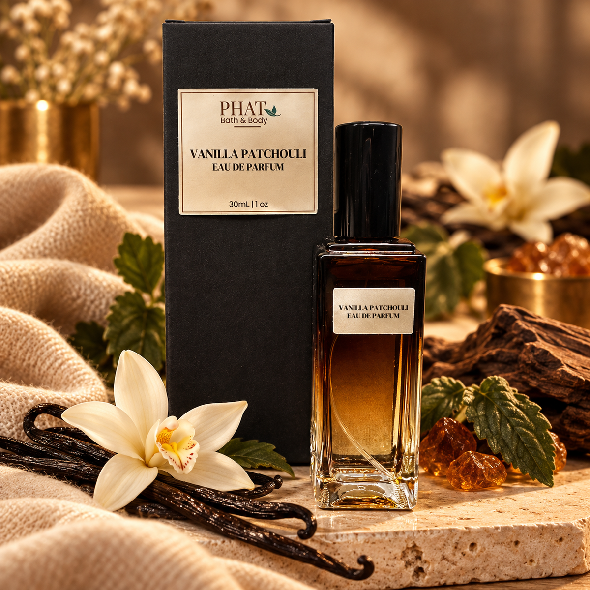Vanilla Patchouli Eau de Parfum with its black Phat Bath & Body packaging, surrounded by vanilla flowers, vanilla beans, green foliage, amber accents, and soft cashmere-inspired fabric.