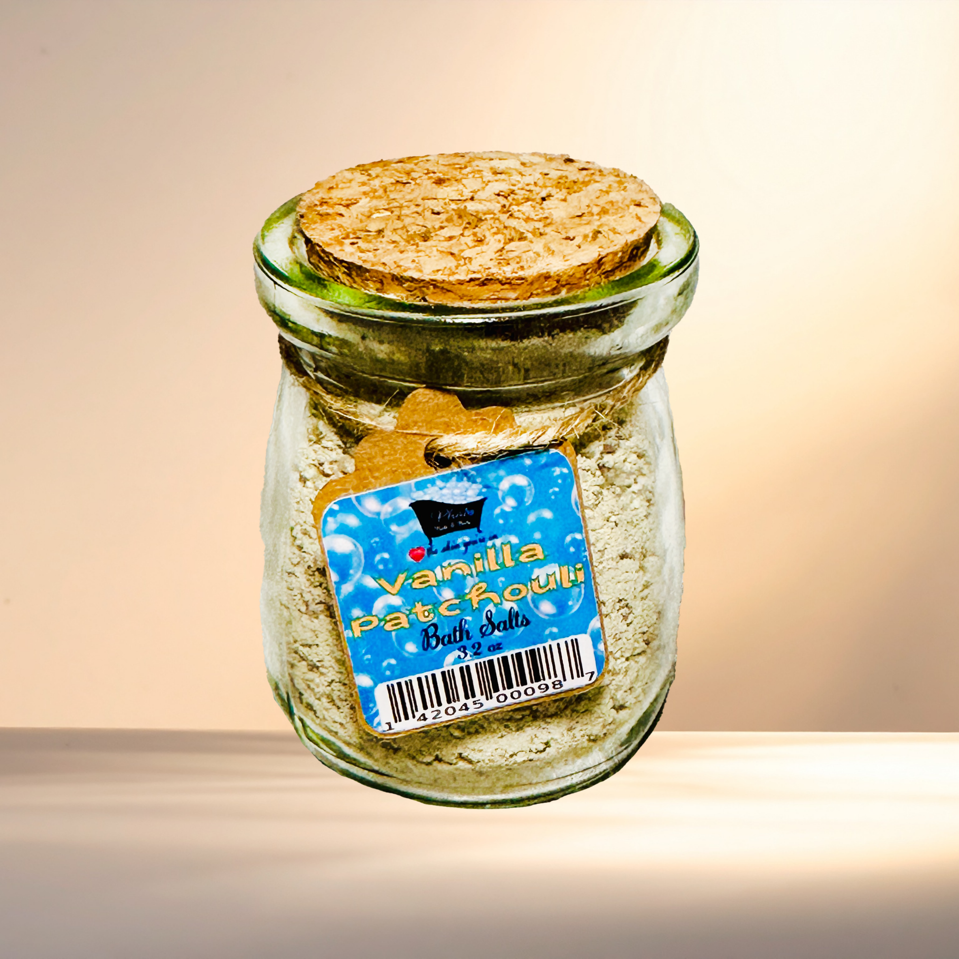 Jar of vanilla patchouli bath salts with a cork lid on a gradient background